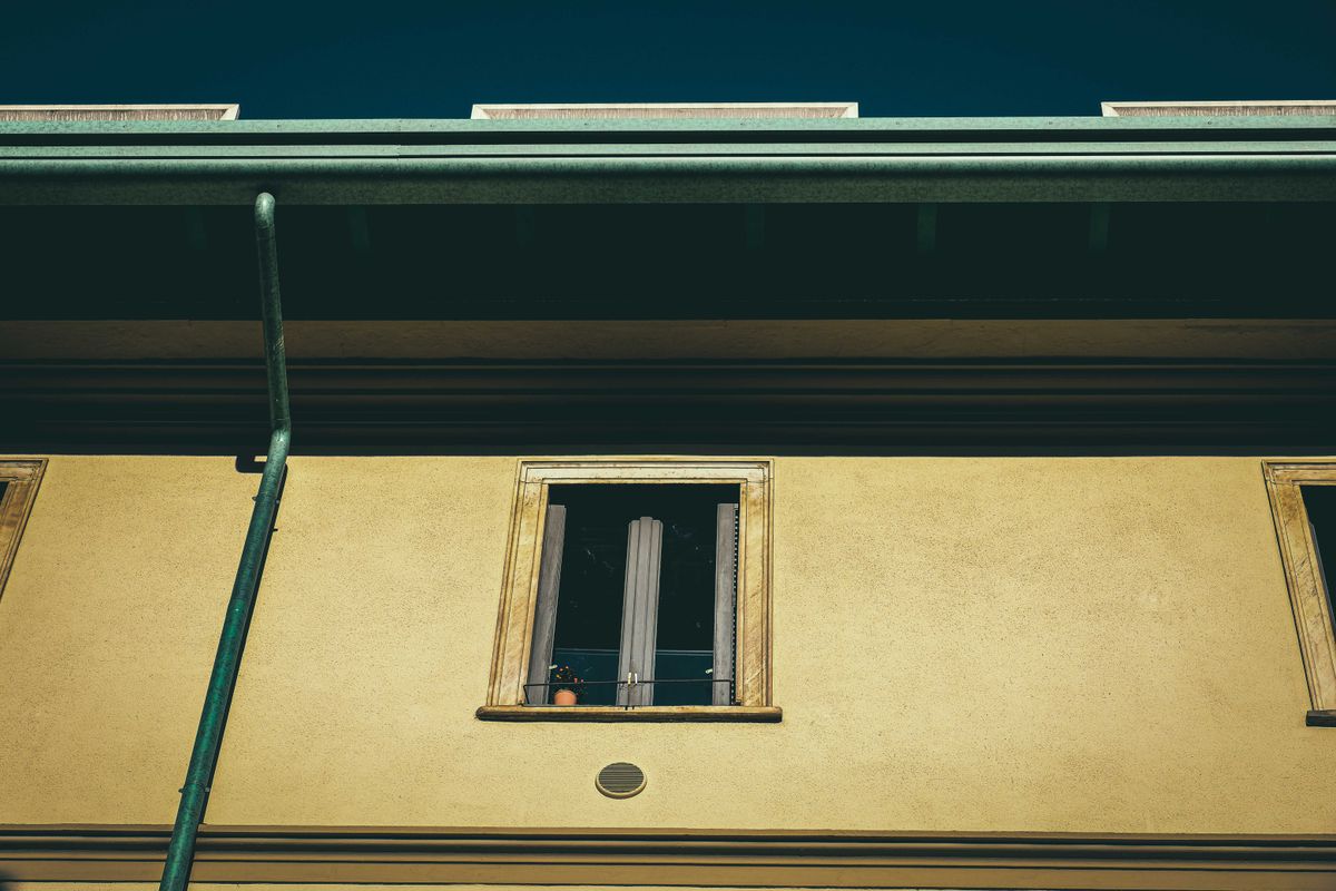Façade d'une maison ancienne avec gouttière et descente d'eau pluviale